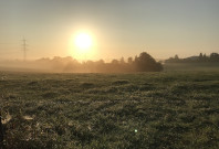 Landschaft mit Sonne im Hintergrund